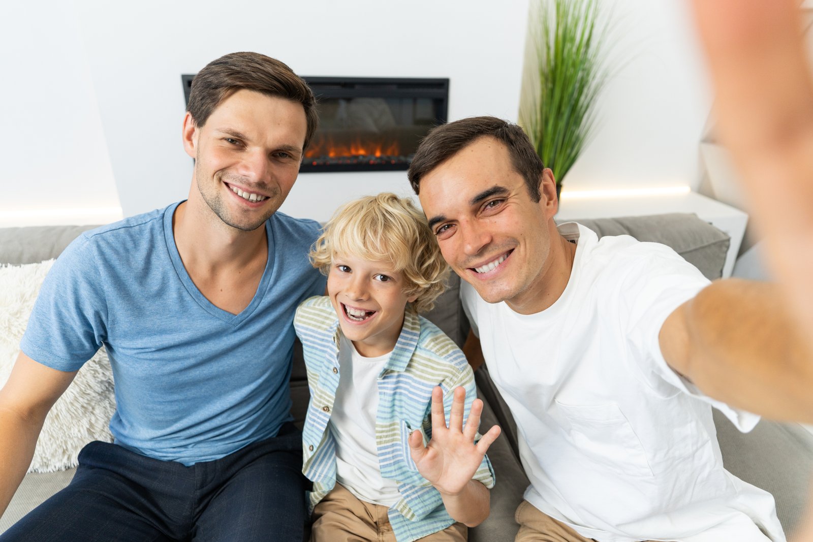 Two dads laughing with their son